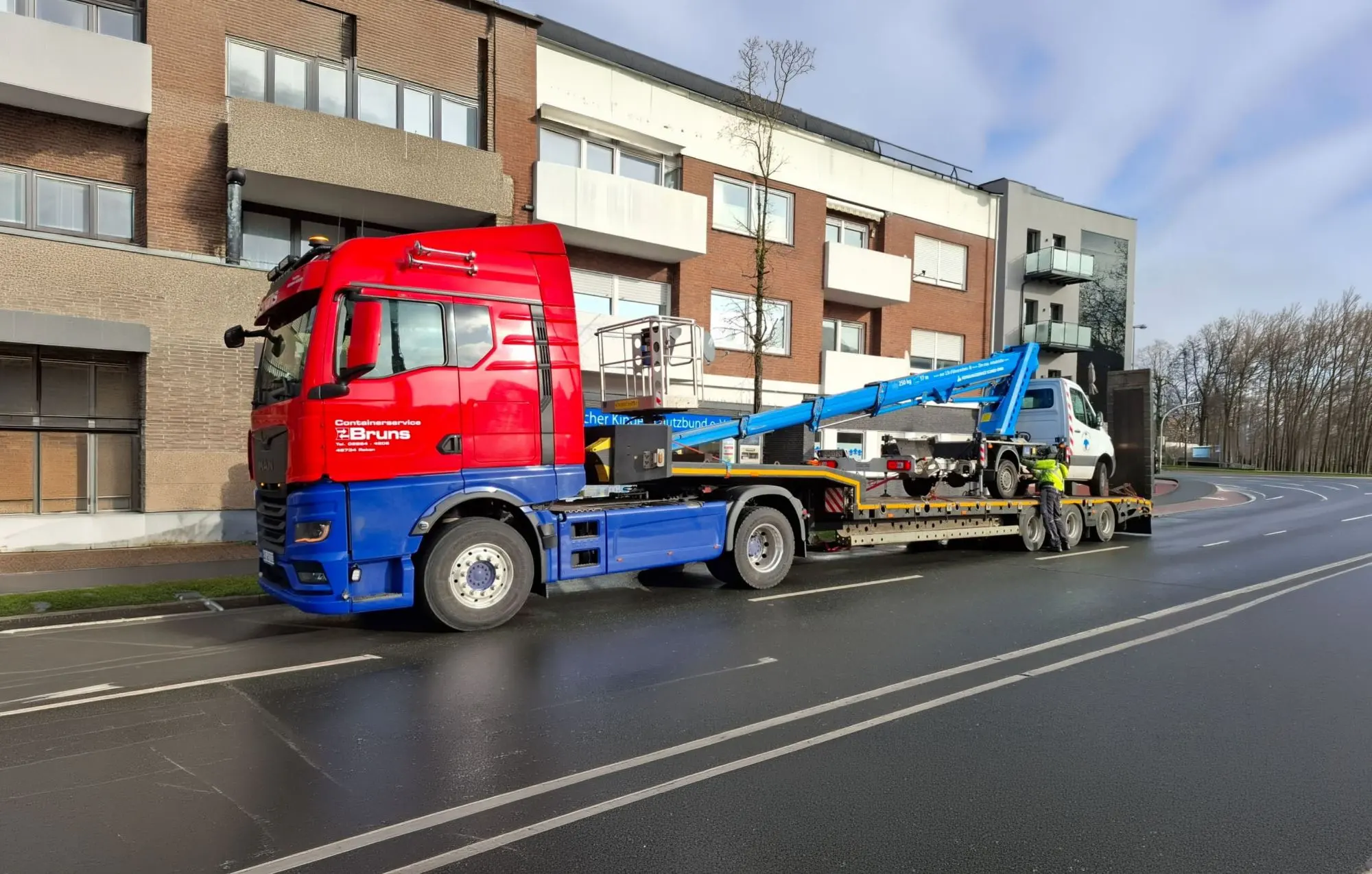 MAN-Sattelzug von Bruns Transporte mit Tiefladeauflieger und verladener Hubarbeitsbühne
